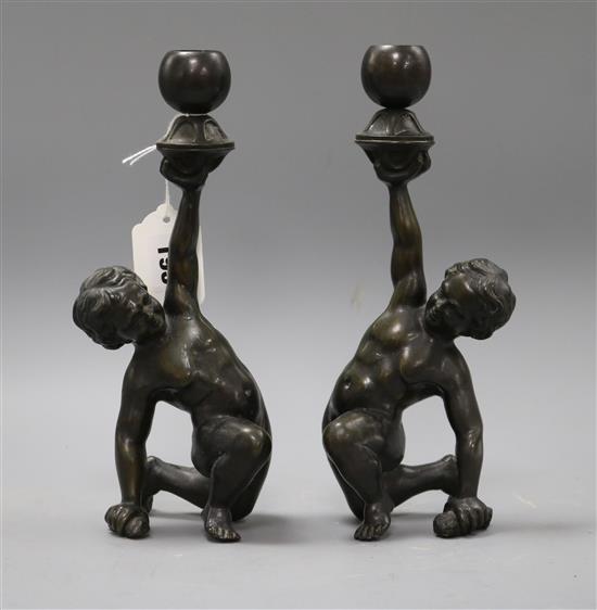 A pair of Italian bronze putto candlesticks height 25cm